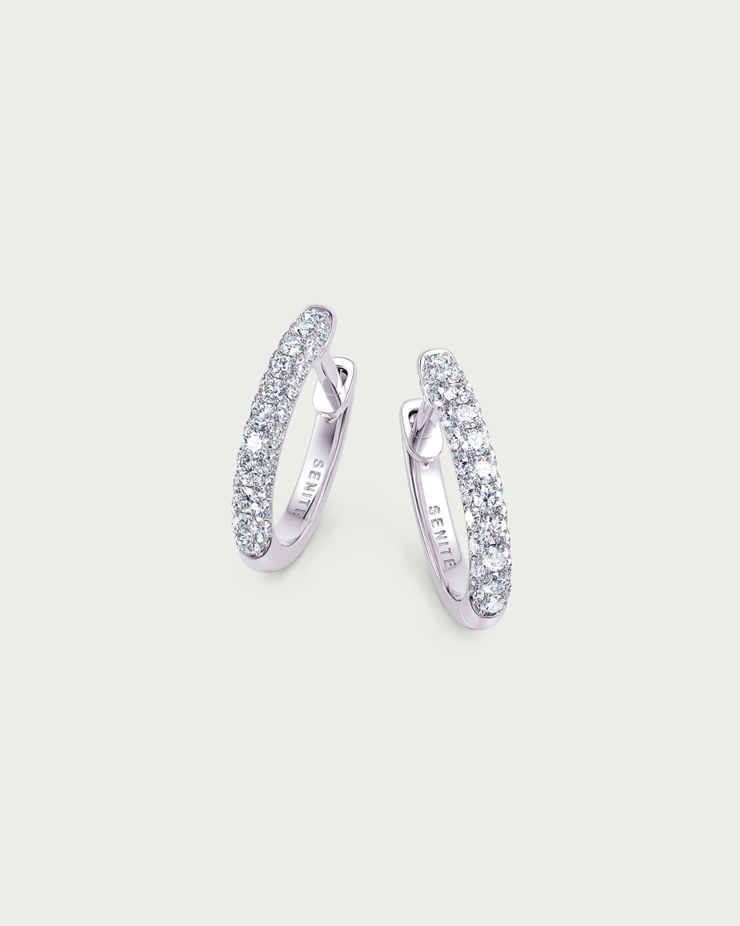 solo product shot of 18k white gold lab grown diamond hoop earrings on off-white background